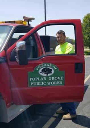 Mitch Hilden standing in front of a red Public Works truck